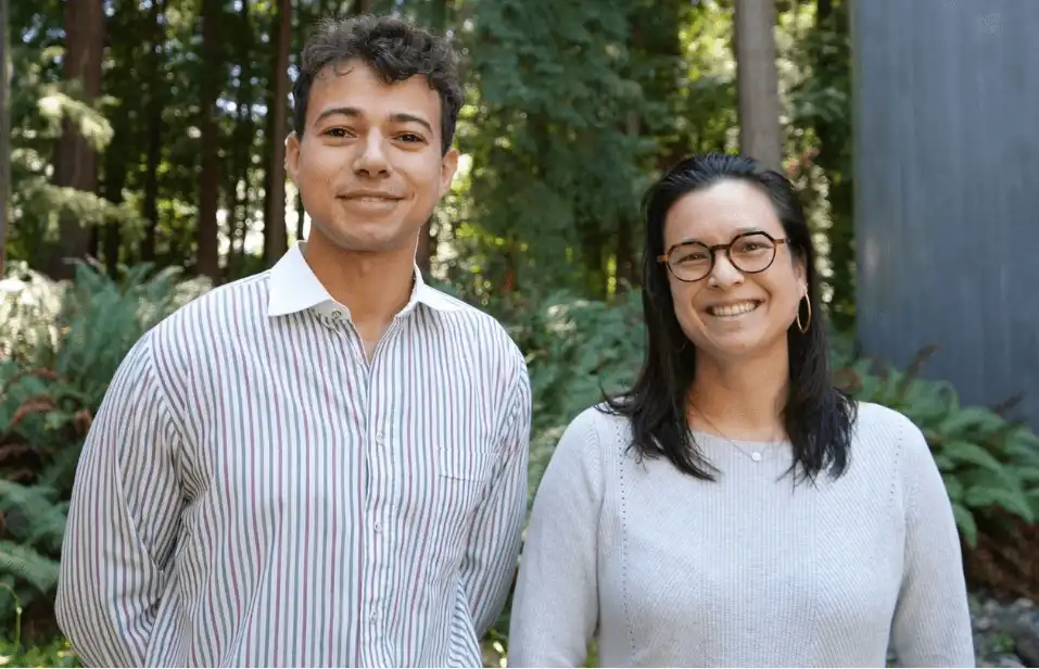 A yound student standing next to a teacher